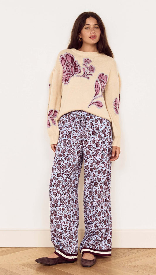 Model wearing the Cream Floral Intarsia Knit Sweater paired with floral print pants and cozy flats.