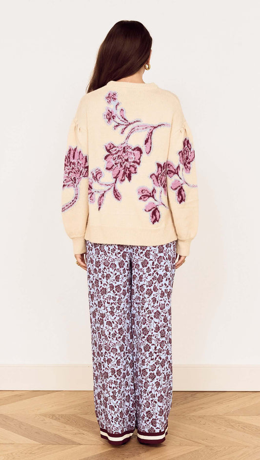 Back view of a model wearing the Cream Floral Intarsia Knit Sweater styled with floral print pants.