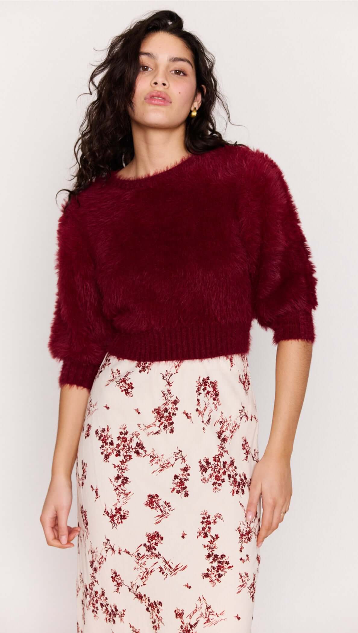 Model showcases the Cream Floral Toile Bias Cut Maxi Skirt paired with a cozy burgundy cropped sweater.