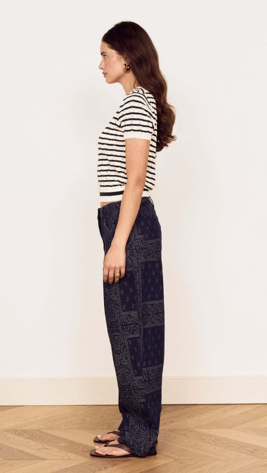 Model wearing Cream Stripe Cotton Pointelle Knit Top with denim pants, showcasing a stylish side profile.