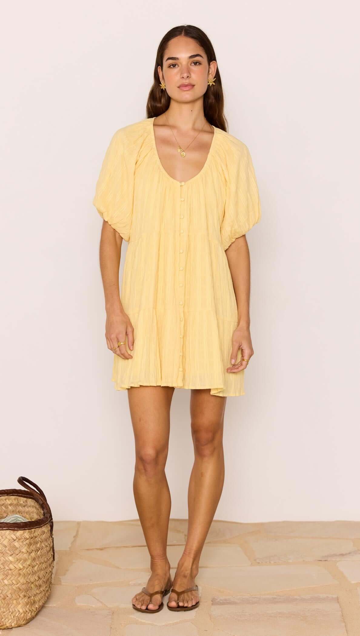 Relaxed Yellow Cotton Tiered Mini Dress worn by a model, showcasing its soft crinkle texture and feminine silhouette.
