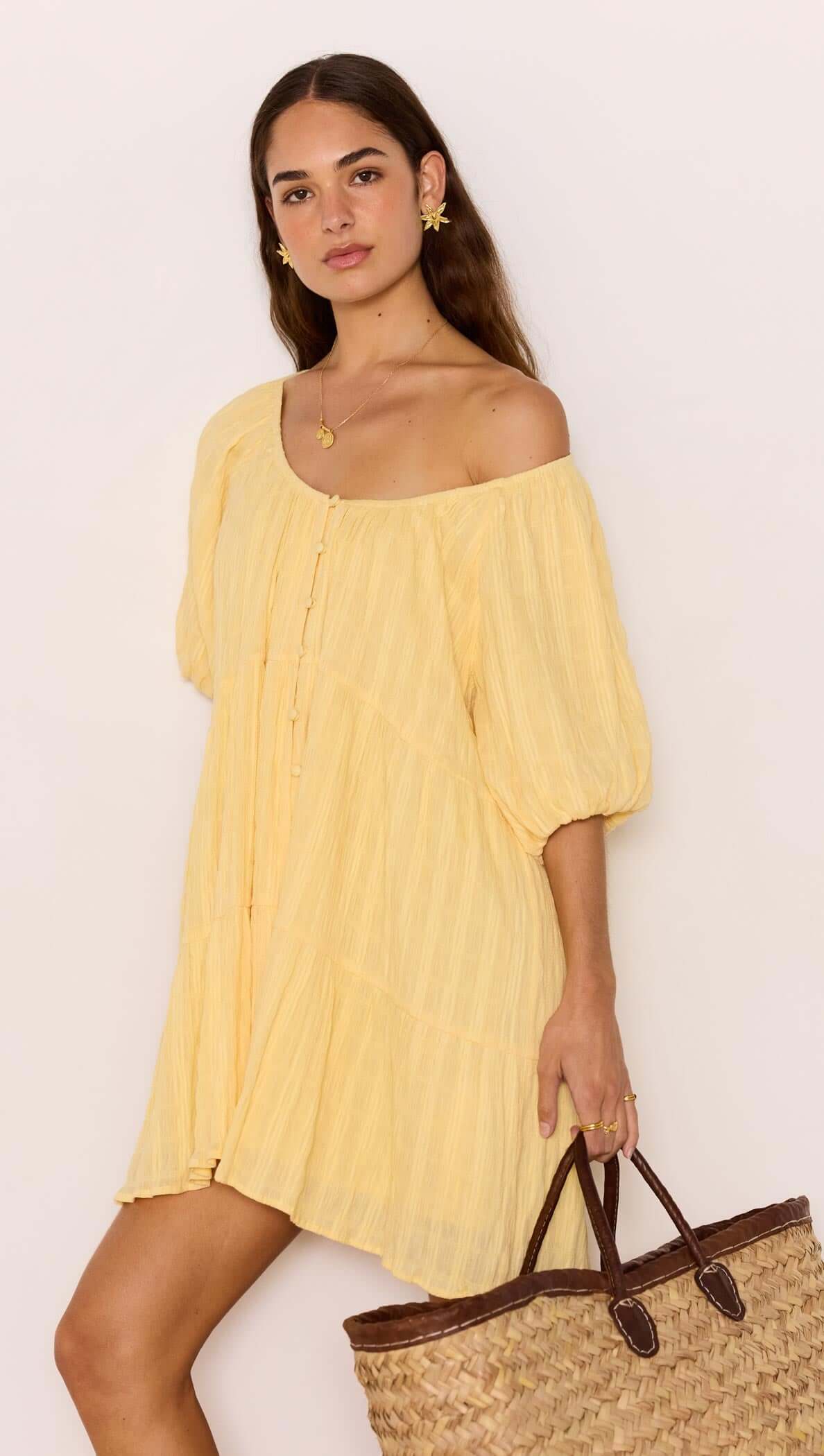 Relaxed Yellow Cotton Tiered Mini Dress worn by model with a straw bag, showcasing a soft crinkle texture and tiered design.