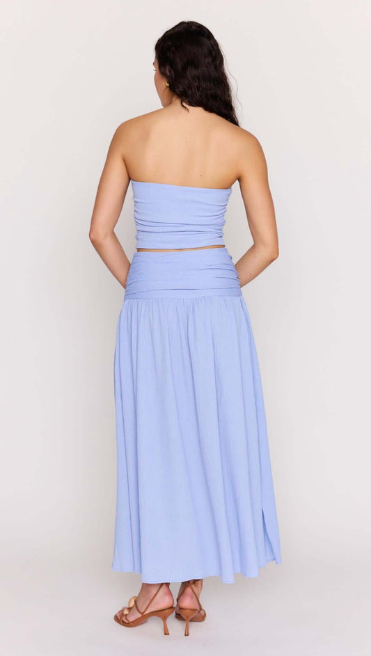 Model wearing a Powder Blue Strapless Crop Top and matching maxi skirt from the back, showcasing soft ruching and a flattering fit.