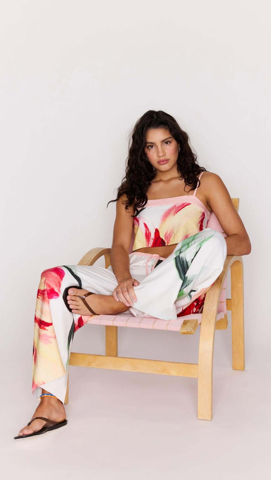 Macro Floral Print Drawstring Pants styled with a floral top, model sitting on a chair with a relaxed look.