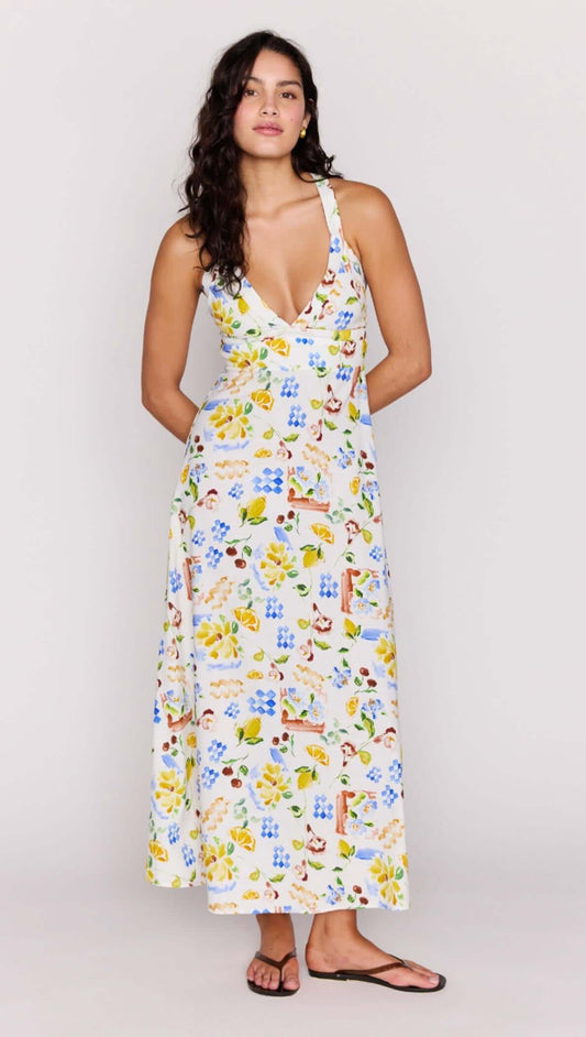 A model wearing the Mediterranean Print Halter Midi Dress featuring a V-neckline and cross-back detail.