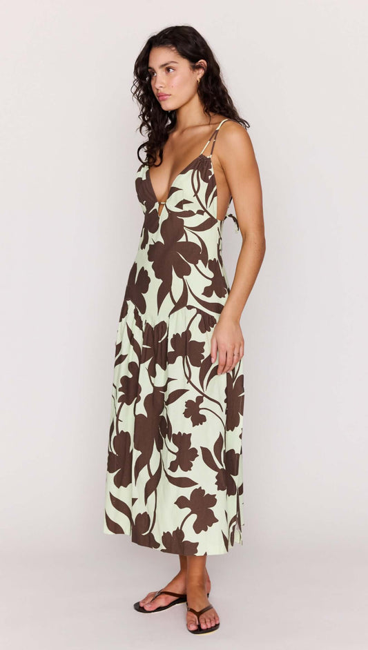 Model wearing Mint Chocolate Cotton Floral Deep V Midi Dress in chocolate floral print with flowing skirt.