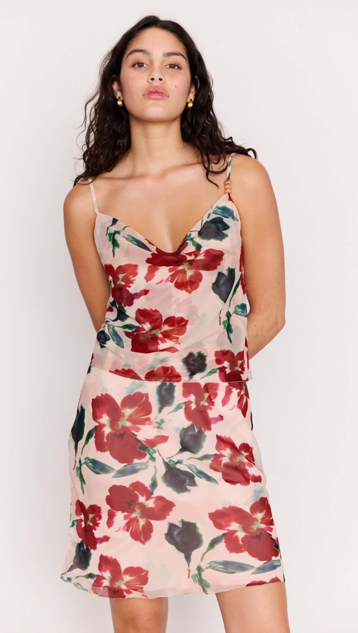 Model wearing a Pink Floral Bias Slip Skirt with a mesh floral top, showcasing a floral print and elegant silhouette.
