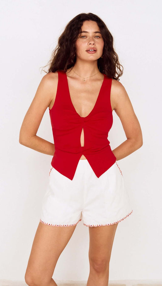 Model wearing a Red Twist Front Jersey Top paired with white shorts, showcasing a stylish summer outfit.