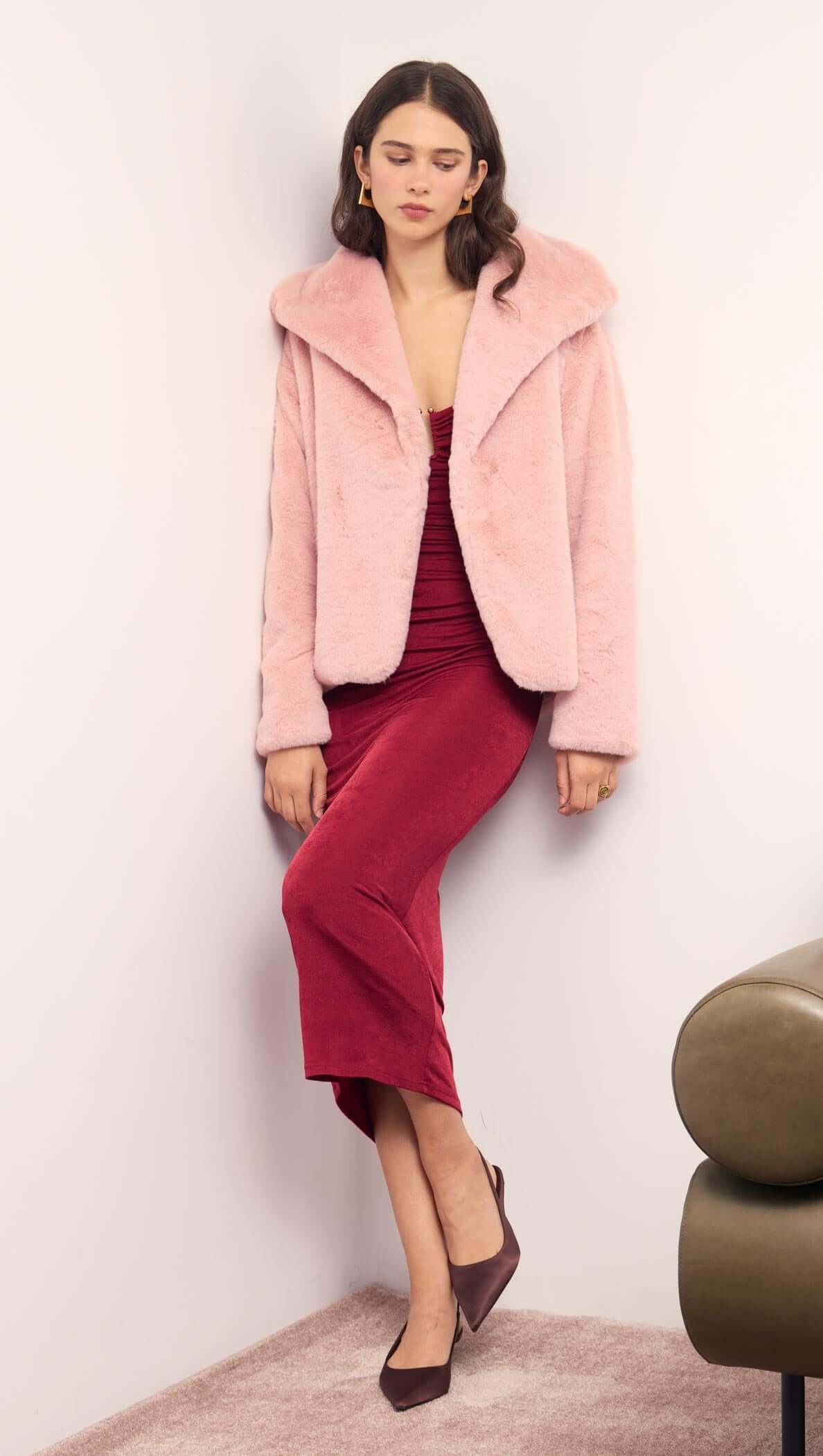 Model wearing a Dusty Pink Faux Fur Coat over a burgundy dress, showcasing a chic winter look.