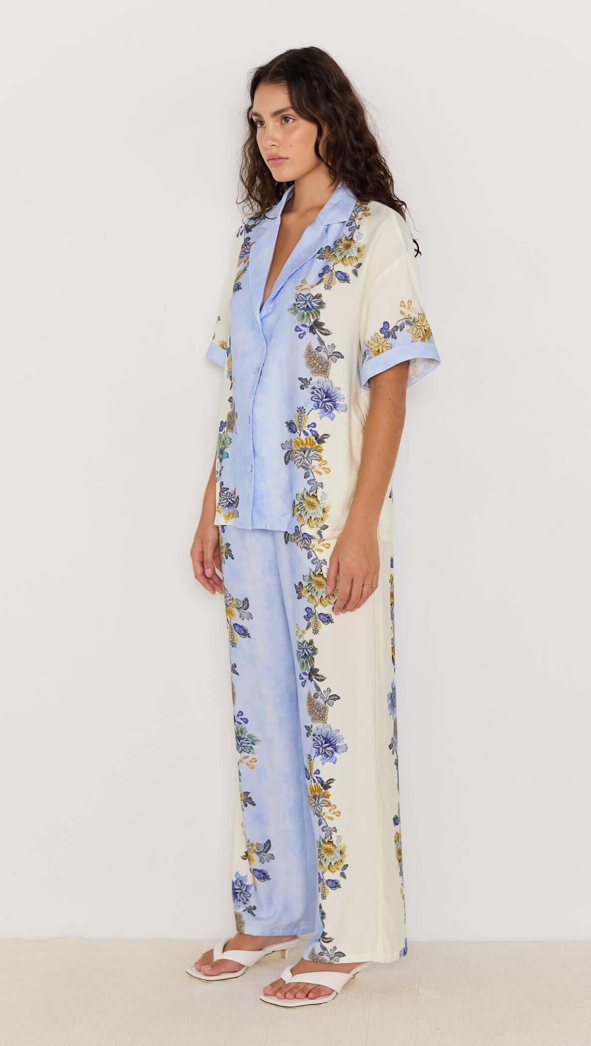 Model wearing Lucia blue floral loose resort shirt and matching pants, perfect for warm-weather styling.