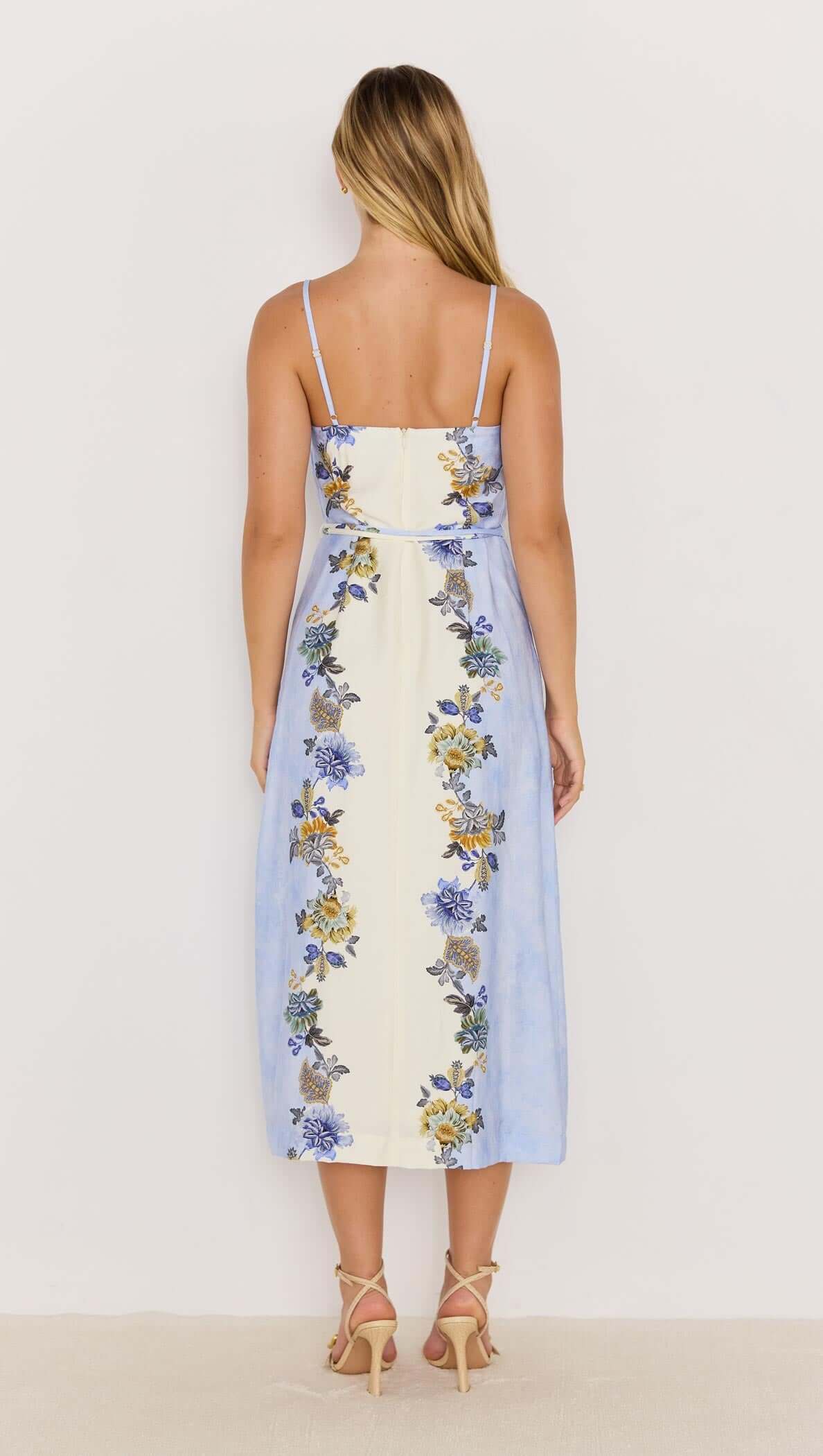 Back view of Lucia blue floral midi dress with tie waist, featuring a flowing skirt and vibrant floral prints.