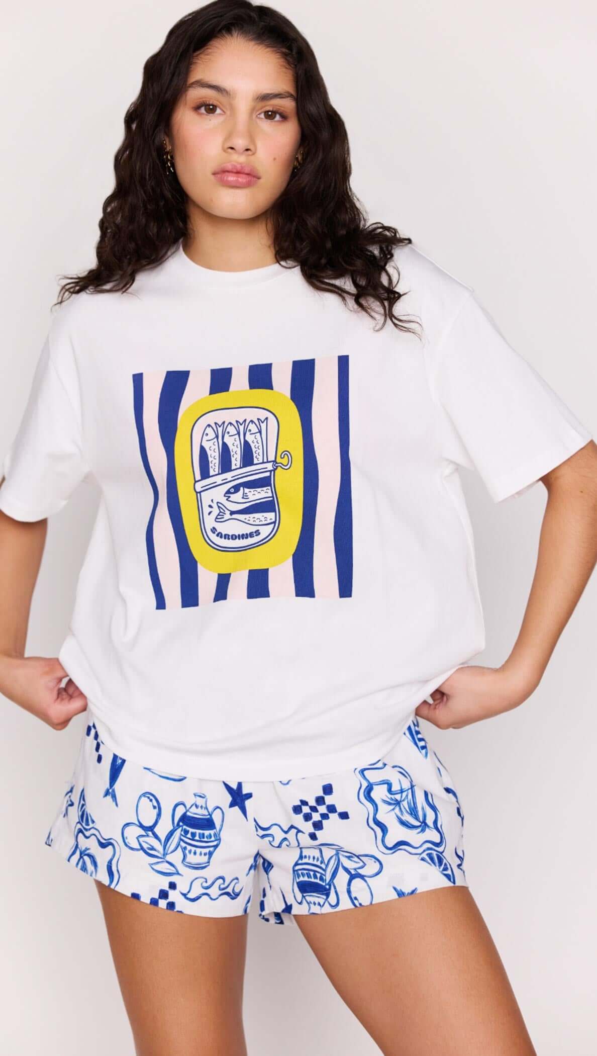 Woman wearing Statement Relaxed Oversized Cotton Tee with Mediterranean print and stylish shorts.