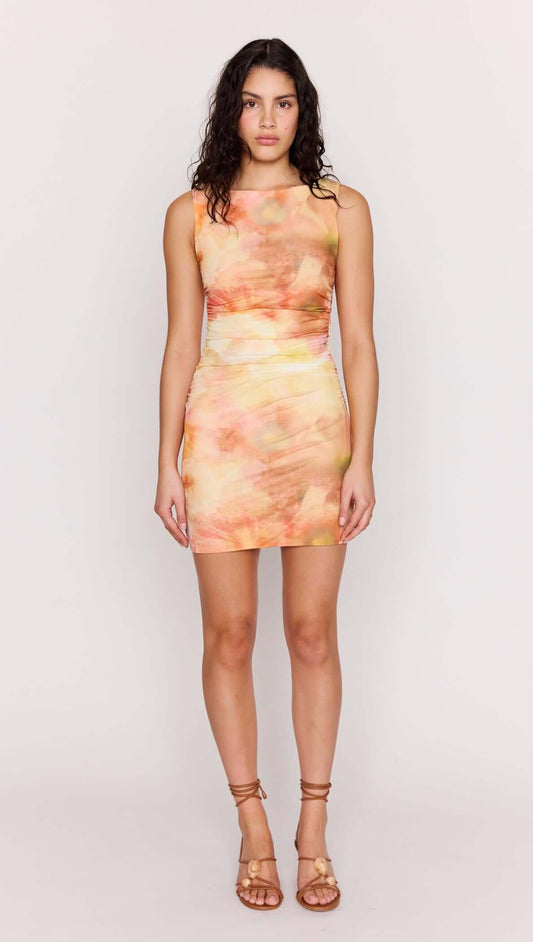 Model wearing a Sunset Tonal Mesh Mini Dress with a watercolor-inspired print in warm sunset colors.