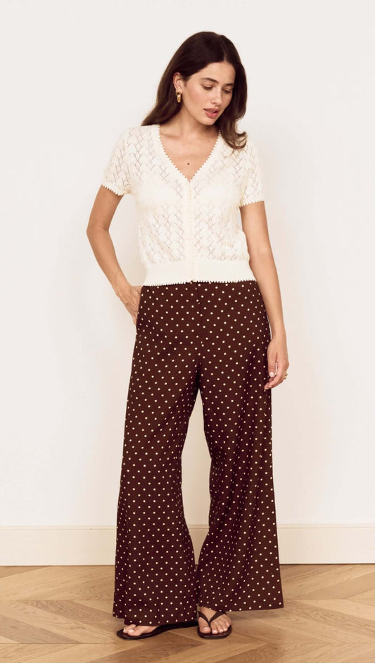 Model wearing a White Cotton Pointelle Knit Top with brown polka dot pants, highlighting a chic layered look.
