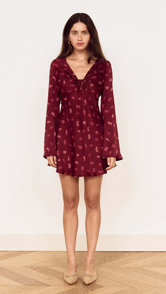 Model wearing a Wine Satin Paisley Knot Front Bias Mini Dress with long flared sleeves and a V-neckline.