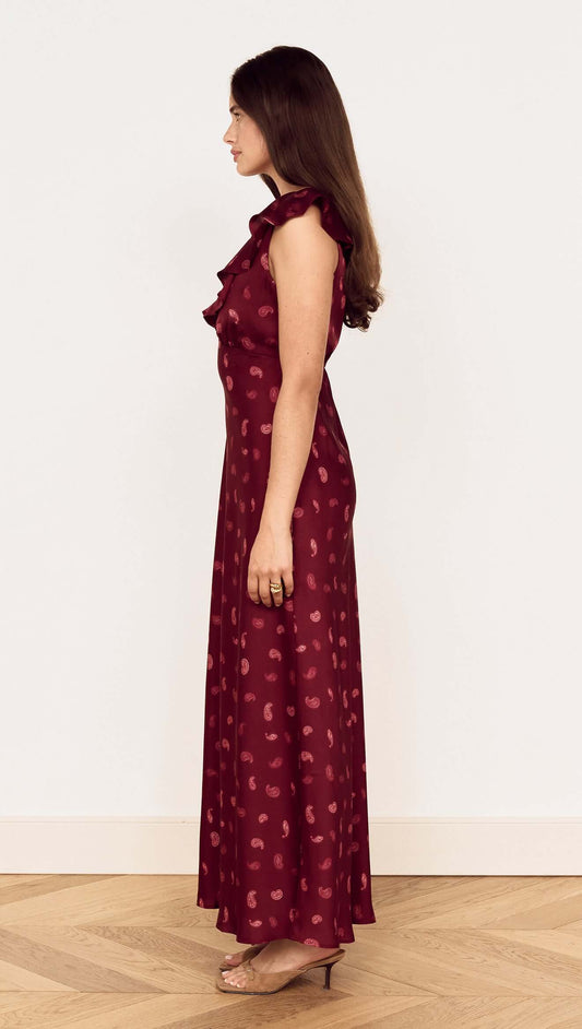 Side view of a woman wearing a Wine Satin Paisley Ruffled Bias Midi Dress, showcasing the elegant silhouette and ruffle details.