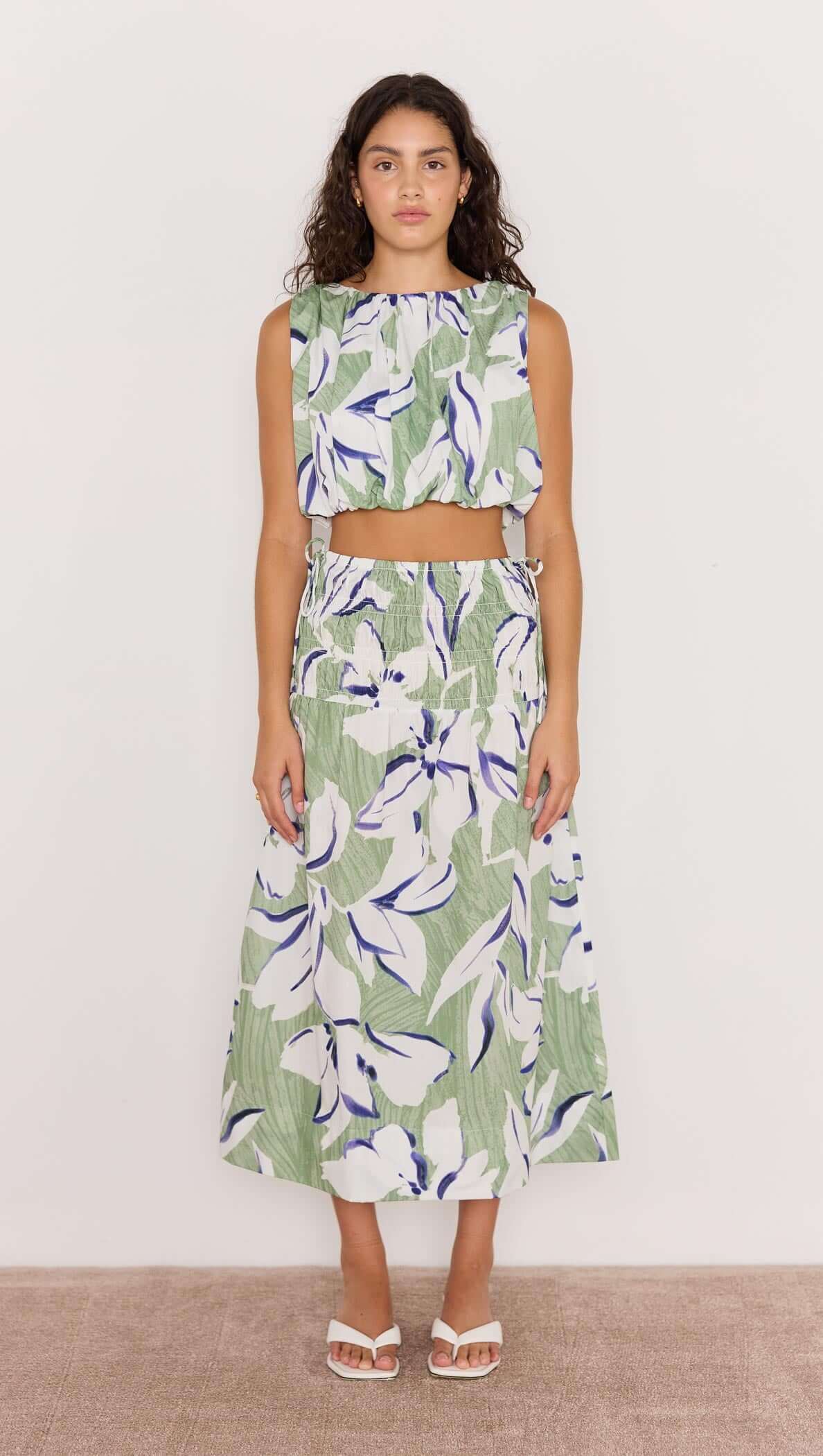 Model wearing a green and white floral bubble crop top with a matching skirt, showcasing a playful summer outfit.