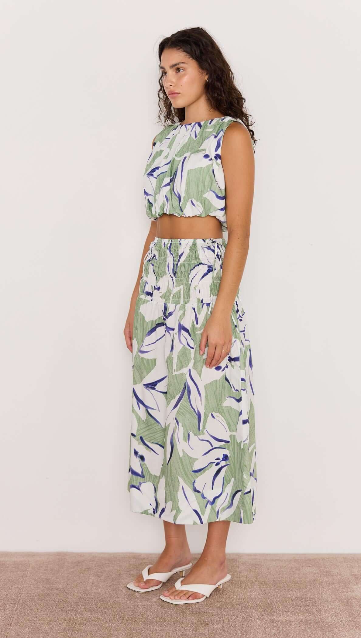 Model wearing a green and white floral midi skirt with a matching top, showcasing a breezy and stylish summer outfit.