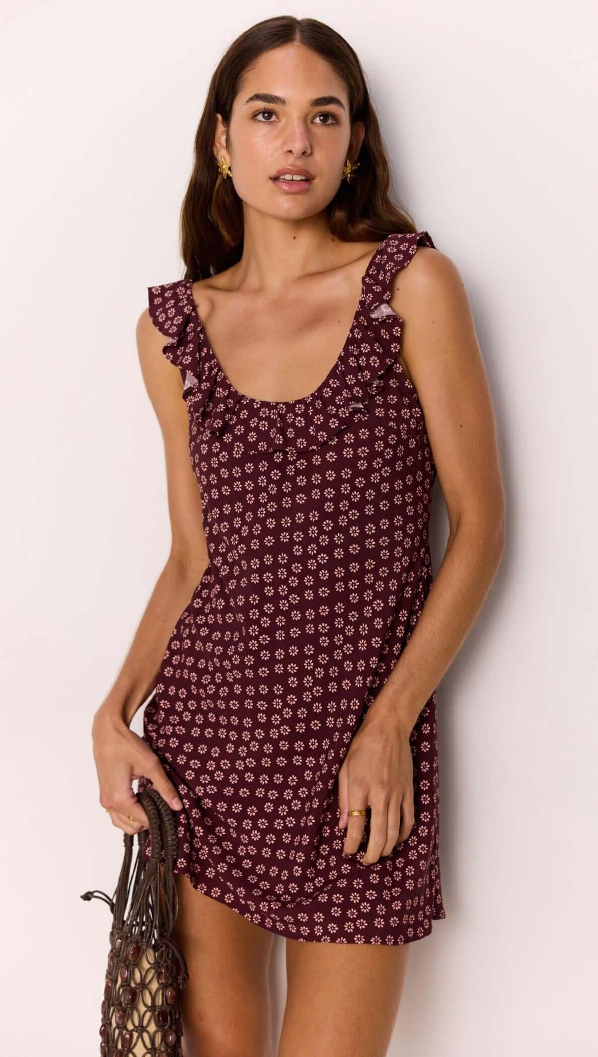 Model wearing a ruffle strap low-back mini dress in burgundy floral print, showcasing a flirty summer look.