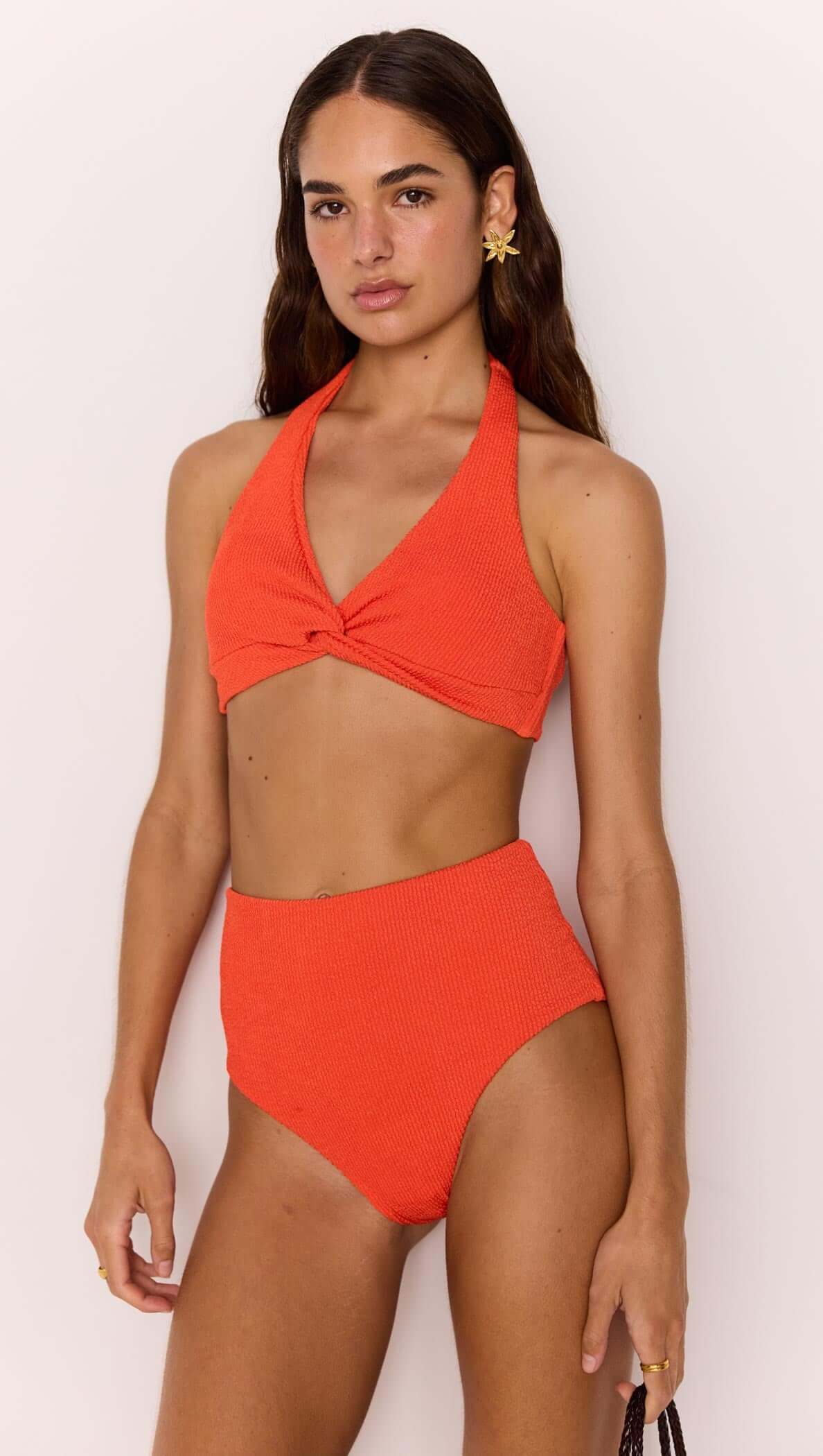 Scarlett Bikini Top and High Waist Bottoms worn by a model showcasing a poppy red bikini set with a halter twist-front design.