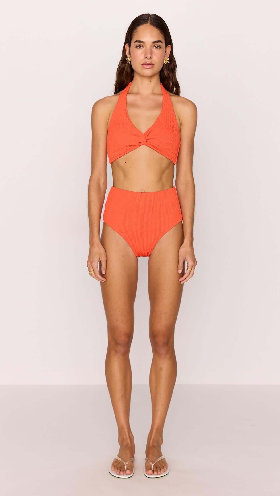 Scarlett Bikini Top and High Waist Bottoms modeled by a woman in a bold poppy red hue with a flattering design.