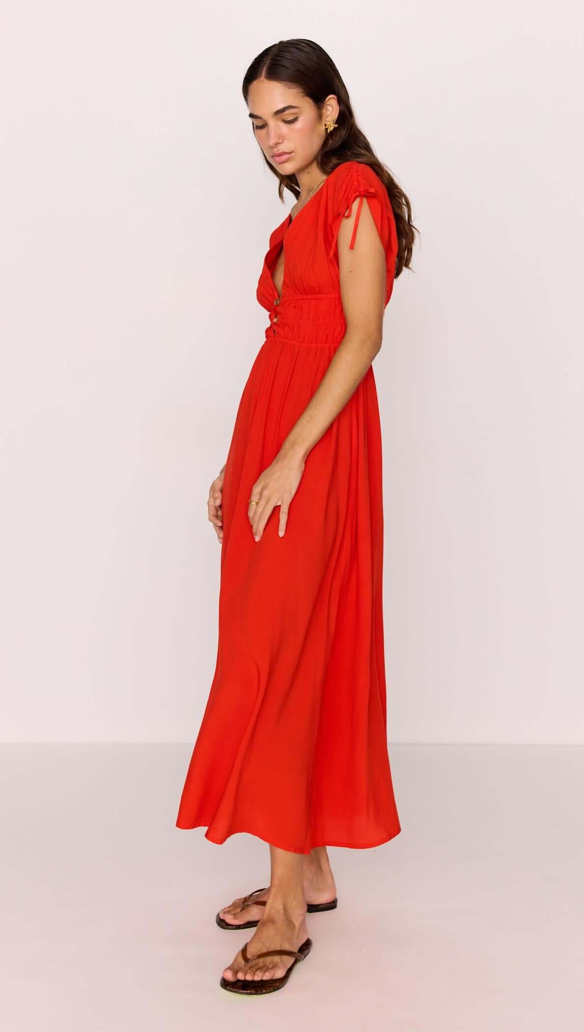 Scarlett V-Neck Midi Dress with Bead Detail in vibrant poppy red, featuring tie detailing and flattering shirred waist.
