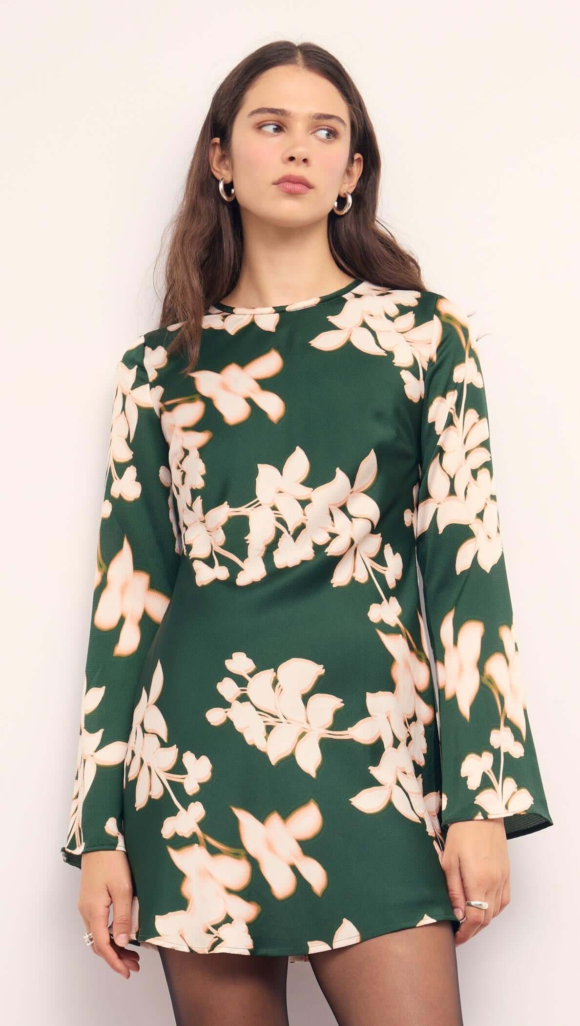 Green & Cream Floral Satin Mini Dress displayed on model, featuring a forest green base with floral patterns and long sleeves.