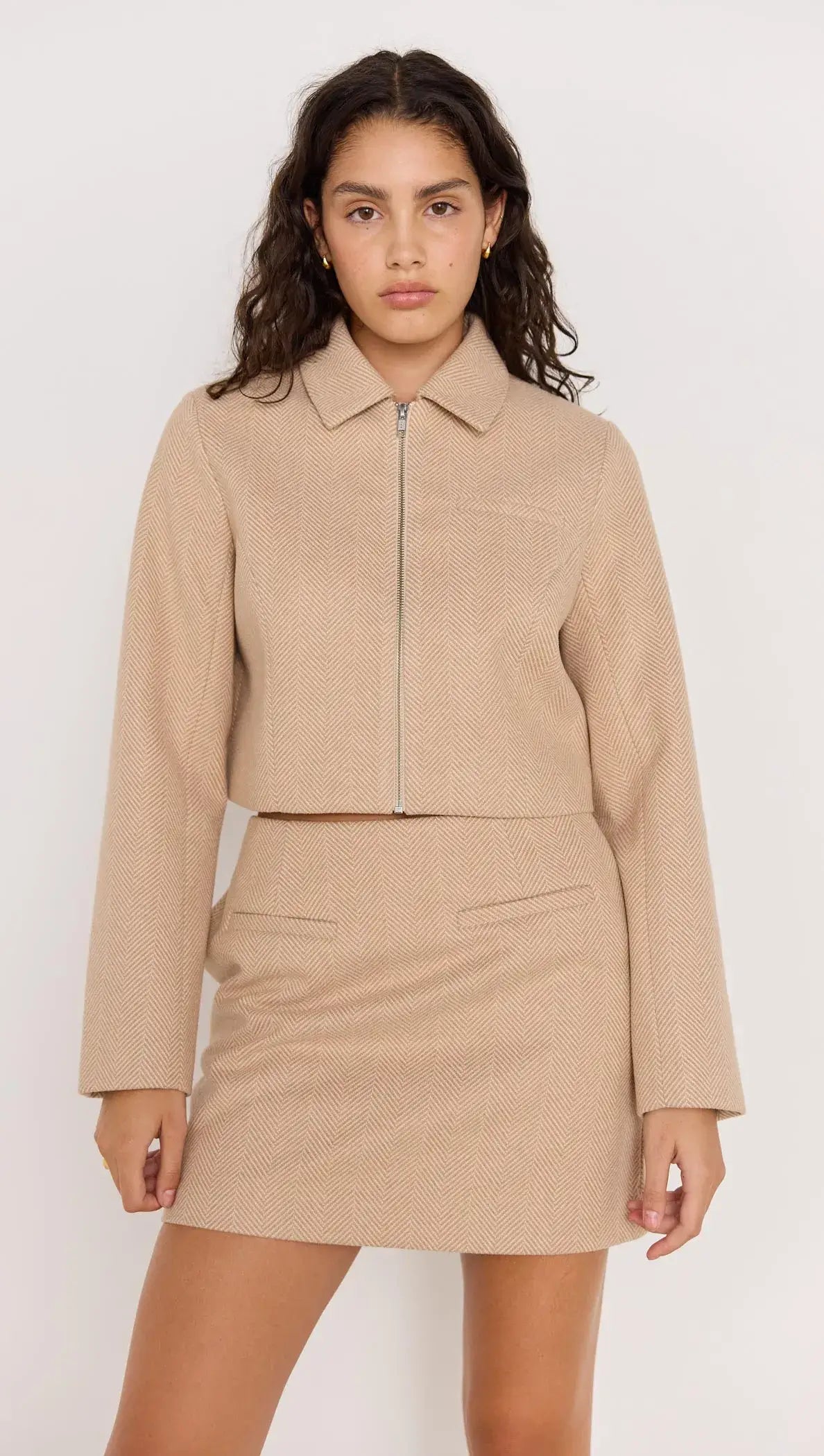 Audrey Herringbone jacket in brown shade, zipped with collar, paired with matching skirt for a chic look.