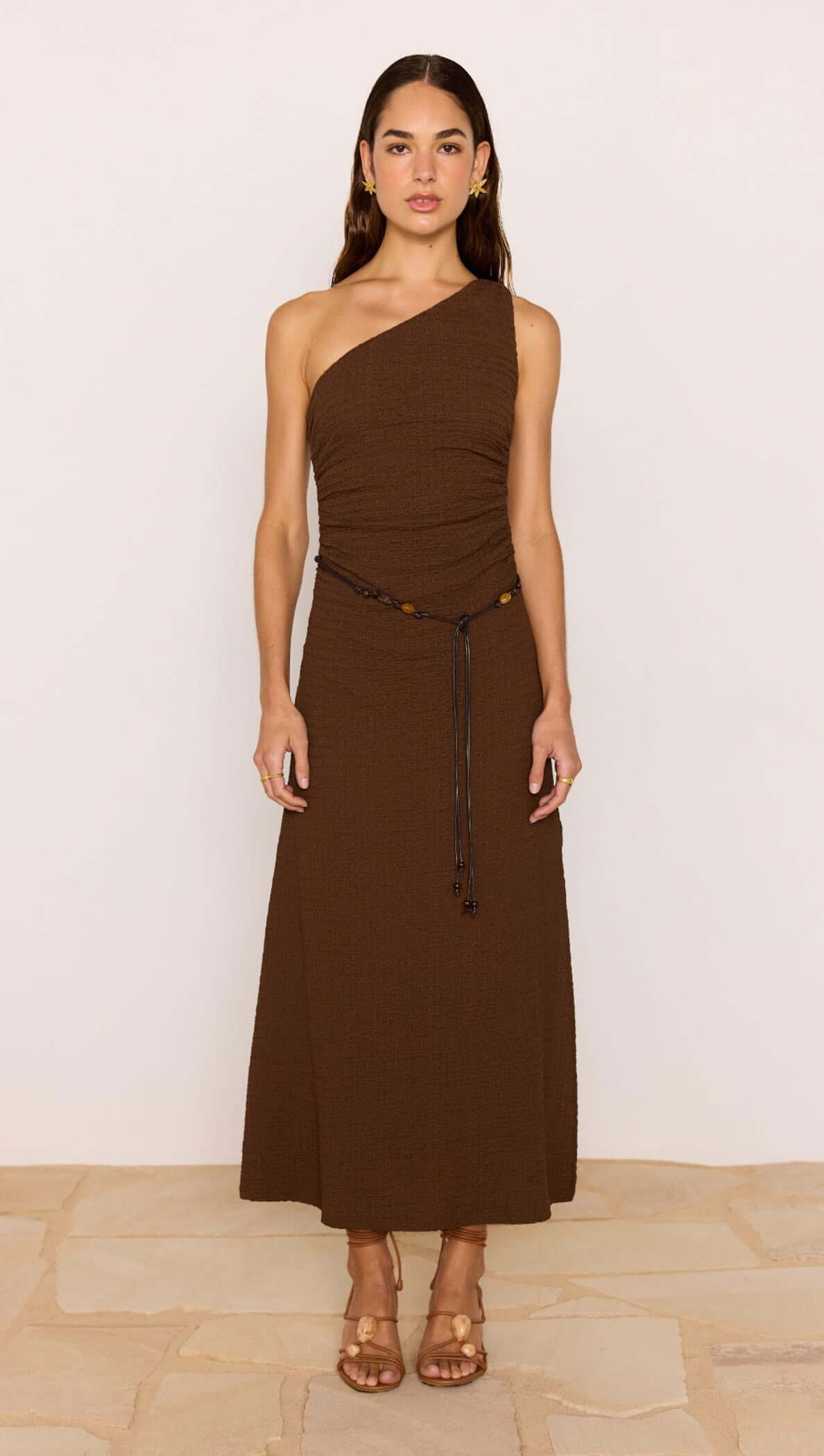 One-Shoulder Brown Midi Dress with Beaded Belt on model in chocolate brown with a ruched bodice and side split.