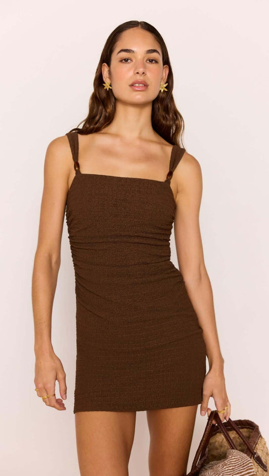 Brown Ruched Mini Dress with Bead Detail modeled by a woman, highlighting the square neckline and ruched design.