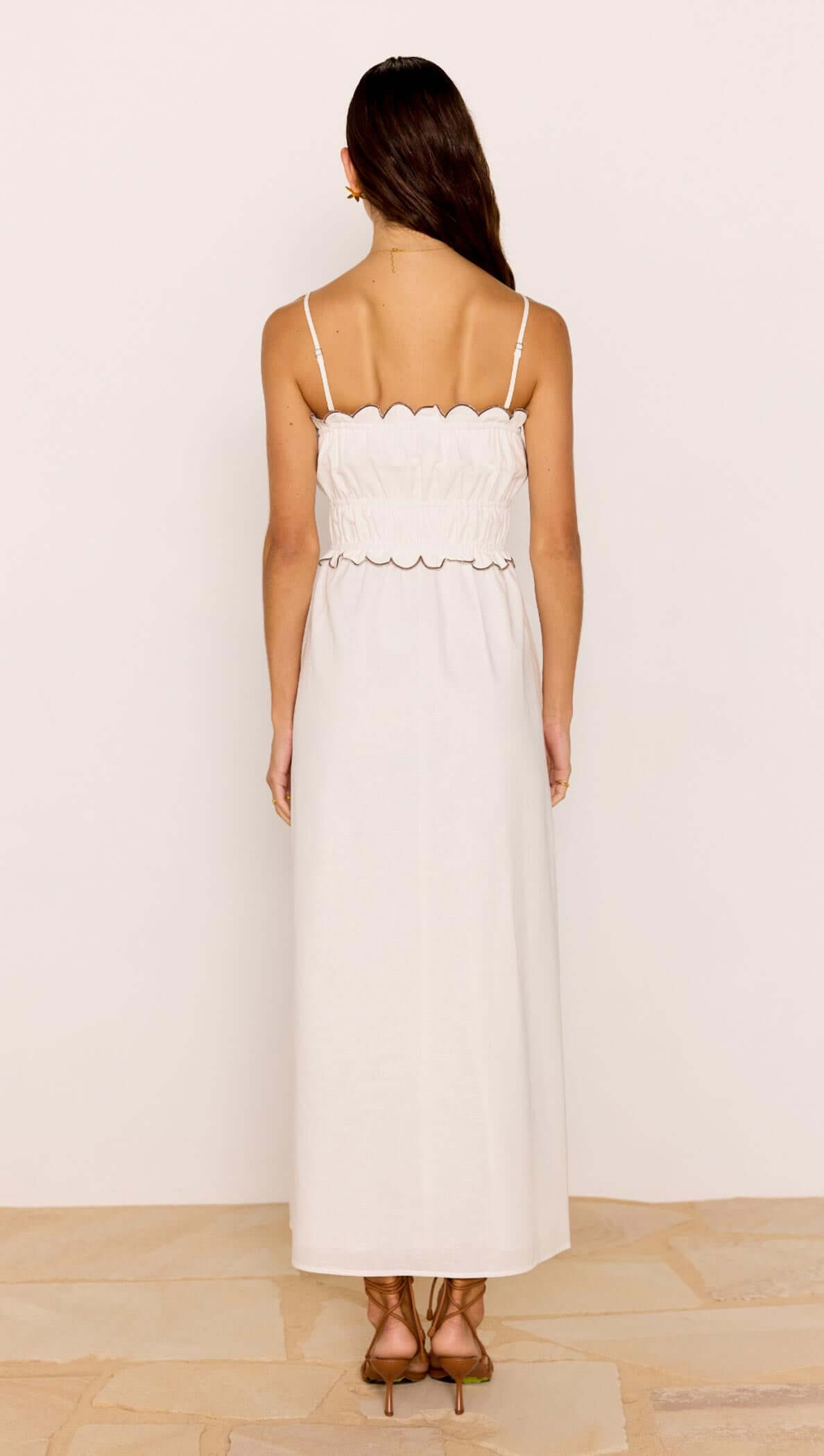 Back view of the Scallop Edge Cotton White Midi Dress showcasing its delicate scalloped hem and shirred bodice.