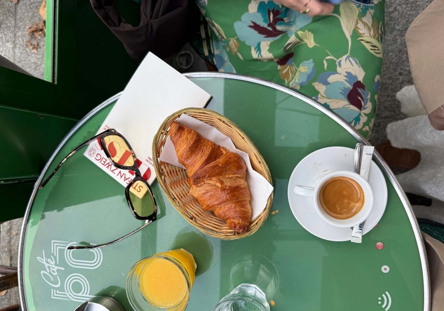 72 hours in Paris travel guide with breakfast at a cafe, featuring croissant and coffee on a green table.