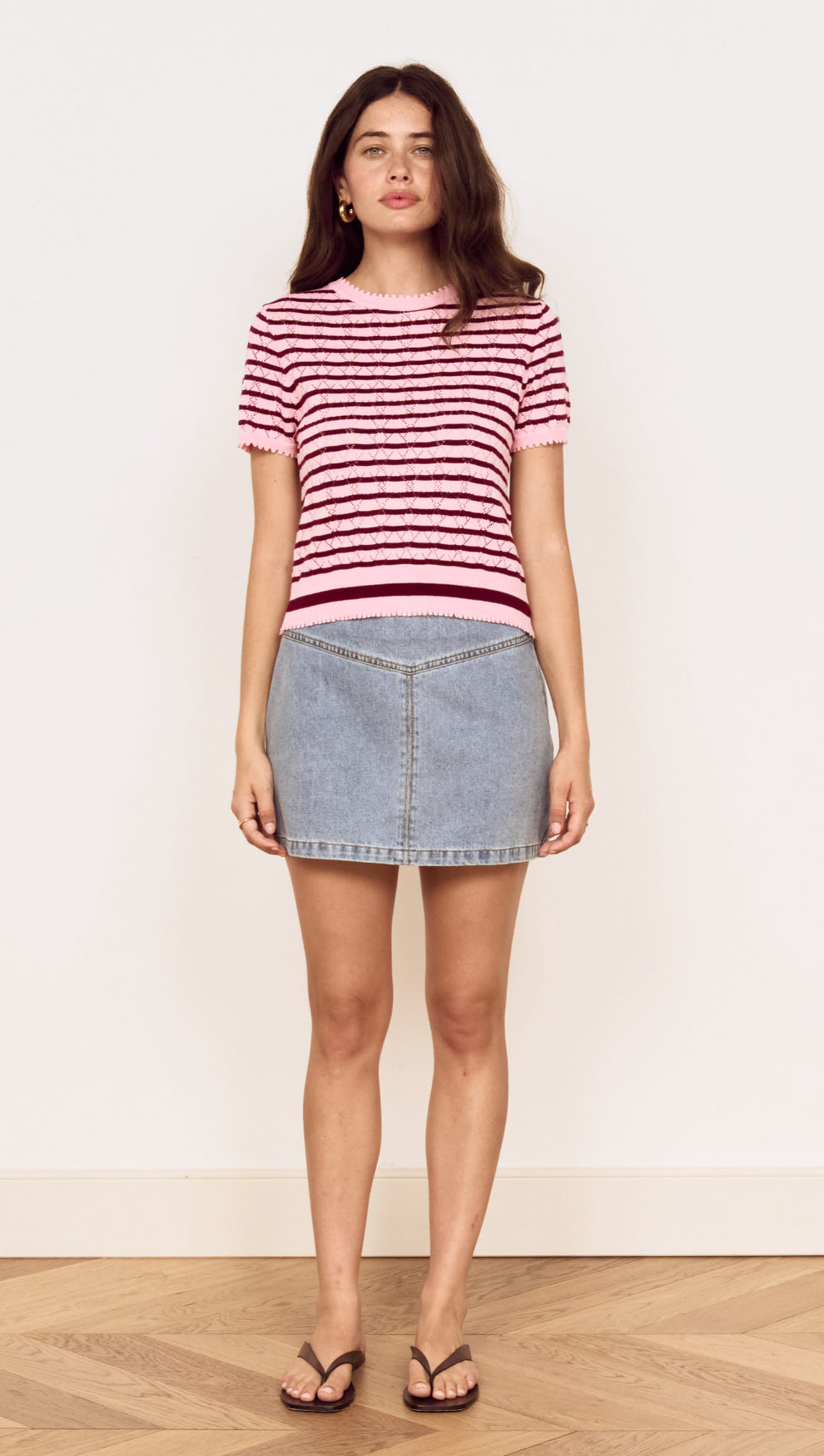 Model wearing a Pink Stripe Pointelle Knit Tee with denim skirt, showcasing a casual summer look.