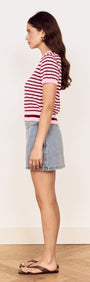 Model showcasing the Pink Stripe Pointelle Knit Tee in pink and burgundy stripes paired with a denim skirt.