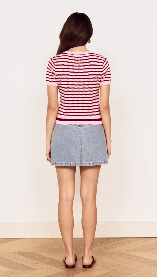 Back view of a model wearing a Pink Stripe Pointelle Knit Tee paired with a denim skirt.