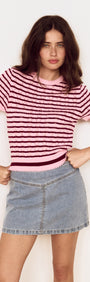 Model wearing a Pink Stripe Pointelle Knit Tee with openwork knit and horizontal stripes, styled with a denim skirt.