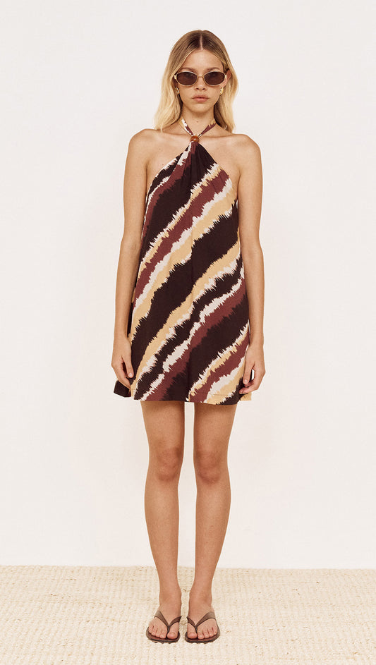 Model wearing Halter Mini Dress in Abstract Stripe featuring a bold diagonal stripe print and halter neckline.