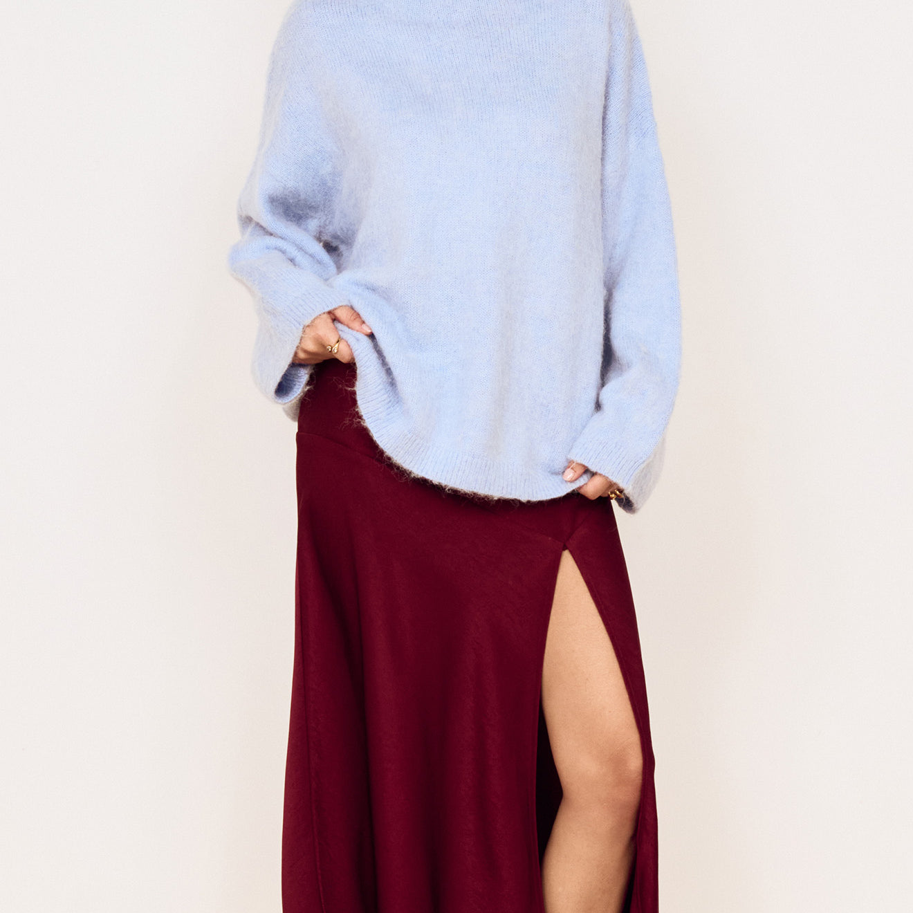 Model wearing a Burgundy Side Split Bias Midi Skirt with a light blue top, showcasing the skirt's elegant split design.