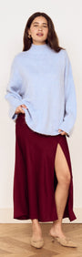 Model wearing a Burgundy Side Split Bias Midi Skirt with a light blue top, showcasing the skirt's elegant split design.