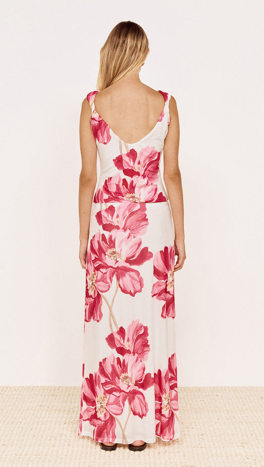 Woman wearing a Pink Floral Mesh Maxi Skirt, showcasing the back view with a bold floral print.