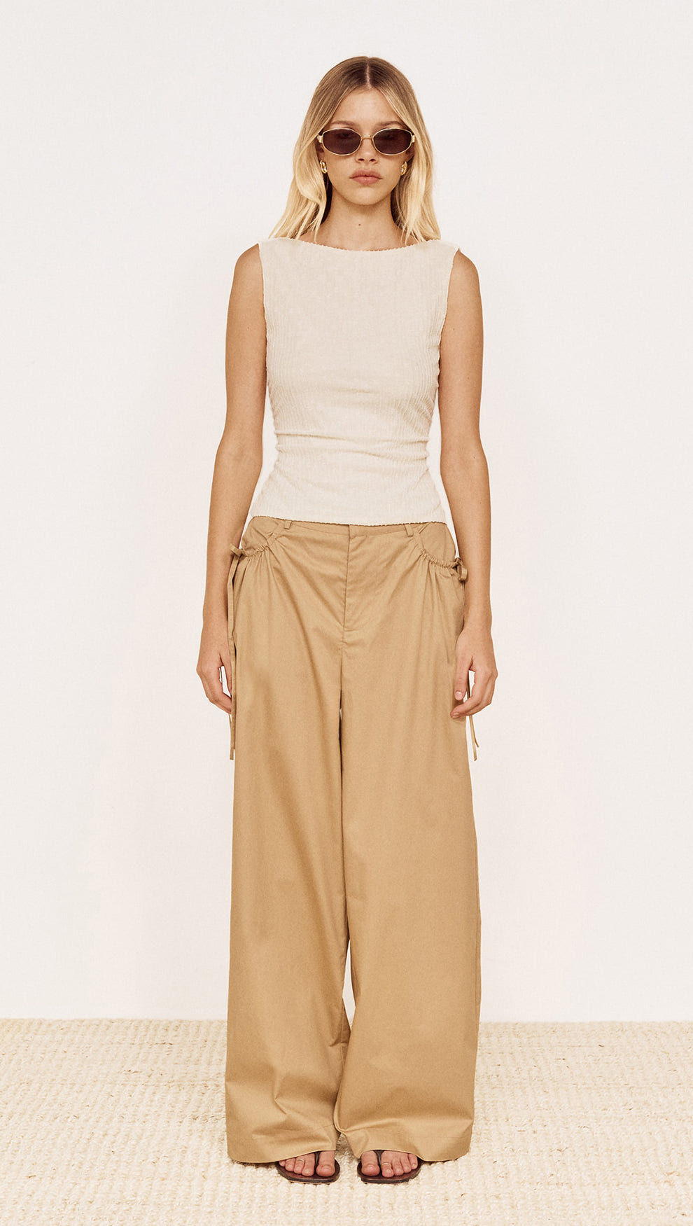 Model wearing a Boat Neck Rib Detail Mesh Top in Cream paired with loose beige trousers and sunglasses.
