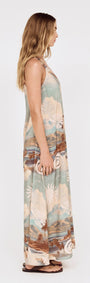 Side view of a model wearing the Island Print One Shoulder Maxi Dress showcasing its scenic print and relaxed silhouette.