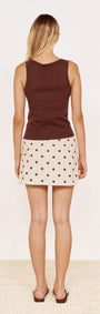 Model wearing Cotton Pointelle Knit Tank in Chocolate with a polka dot skirt from the back on a neutral background.