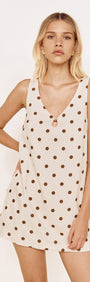Gold Detail Keyhole Mini Dress in Chocolate Spot worn by a model, featuring a cream base with chocolate spots and a keyhole neckline.