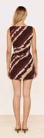 Back view of a model wearing a fitted Mesh Mini Dress in Abstract Stripe with rich chocolate and neutral tones.