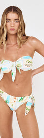 Model wearing the Island Postcard Low Rise Knotted Bikini Bottom and matching top, featuring a vibrant postcard-inspired print.