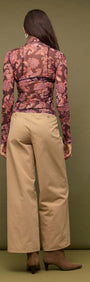 Back view of model wearing Sheer Printed Long Sleeve Mesh Top paired with beige wide-leg pants.