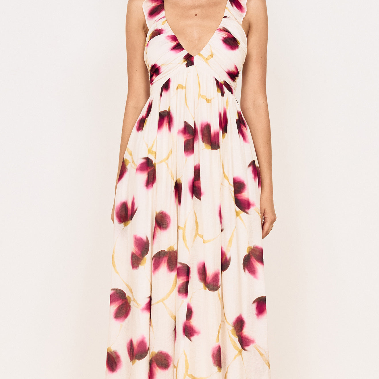 A model showcasing a Floral Ruffle Detail Bias Maxi Dress with a floral print in berry and golden tones.