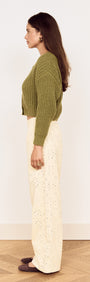 Side view of a model wearing a Green Cable Knit Cropped Cardigan paired with light-colored wide-leg pants.