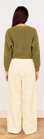 Back view of a model wearing a Green Cable Knit Cropped Cardigan with cream wide-legged pants.